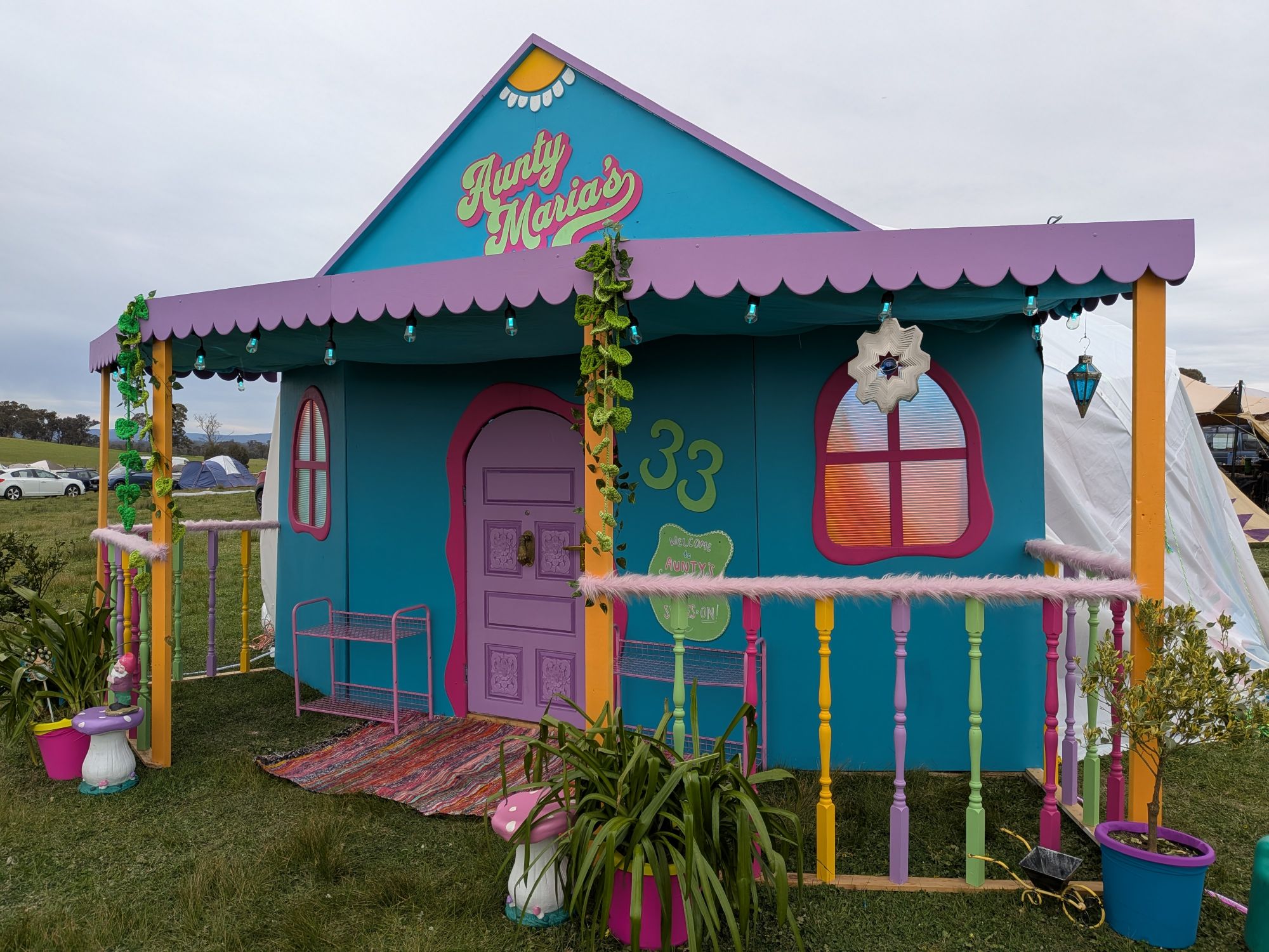 The Aunty Maria’s house: a teal facade with a scalloped lilac awning, arched pink windows, rainbow balustrades and crochet vines