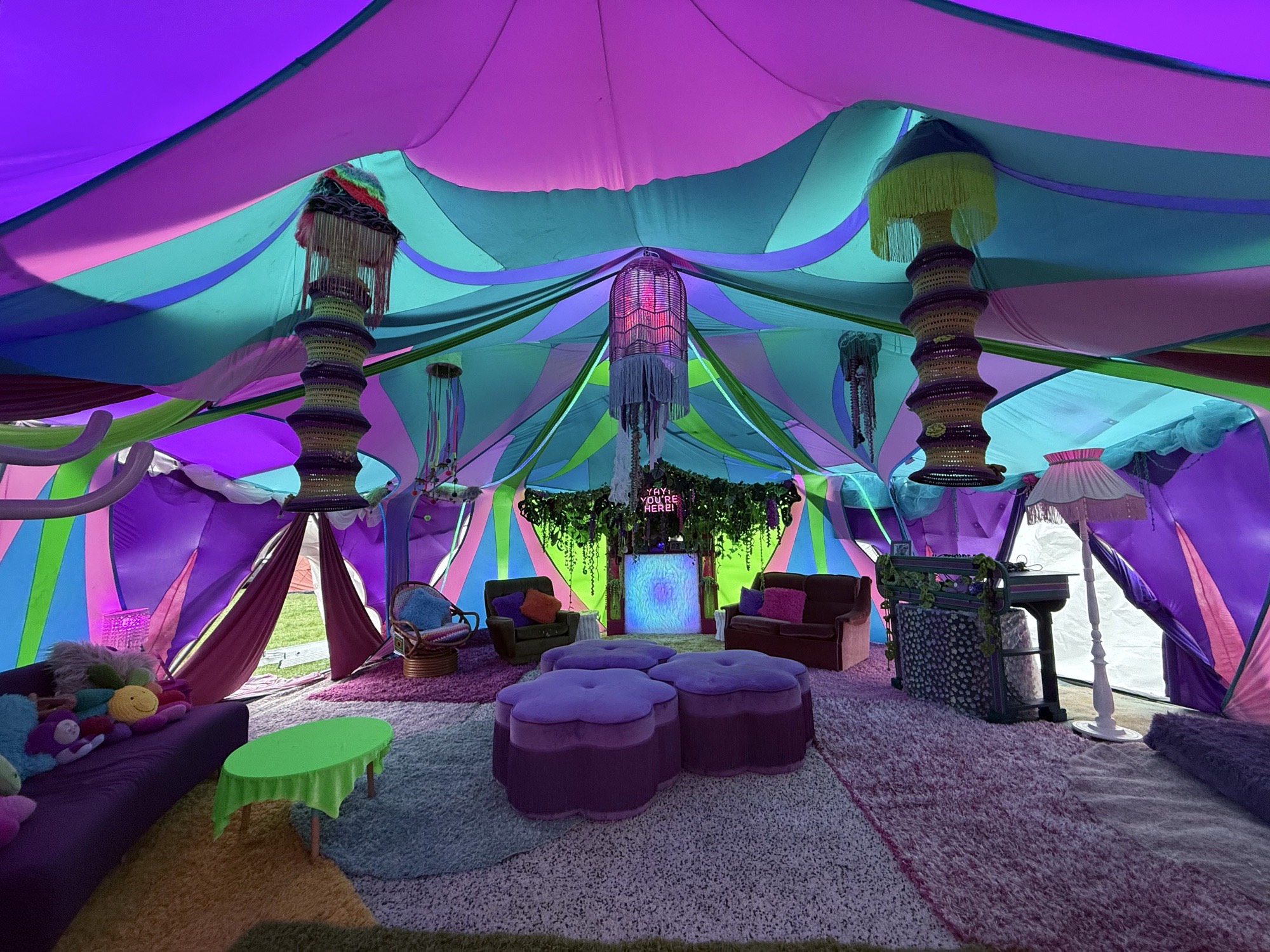 Inside the Aunty Maria’s tent by day: pastel draped canopy, tasselled lanterns, couches, ottomans and the crochet-draped fireplace